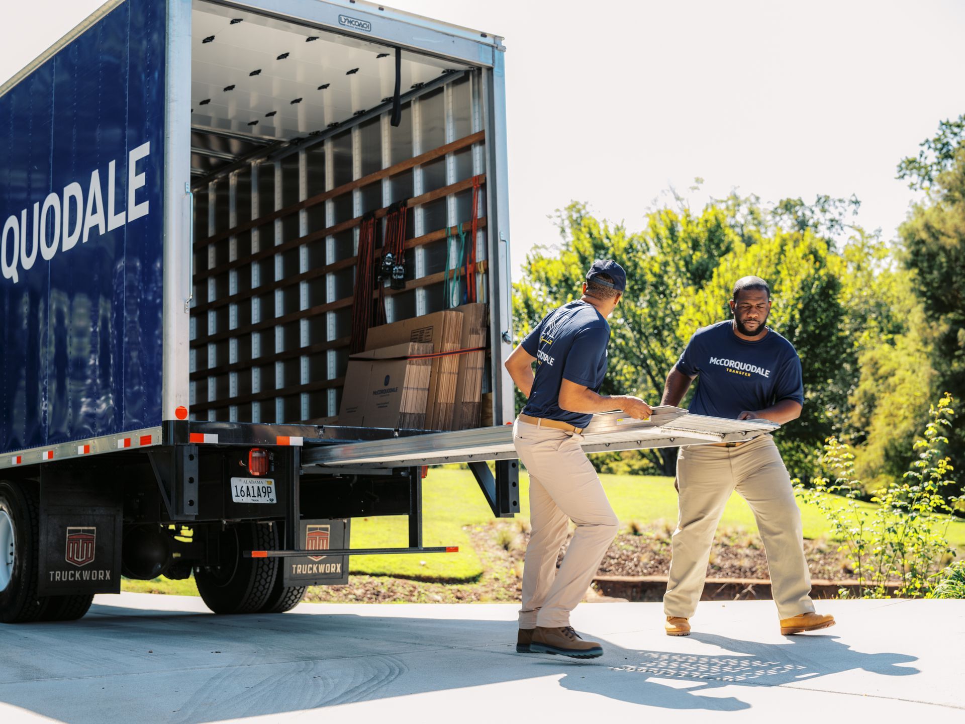 Two people loading a truck labeled