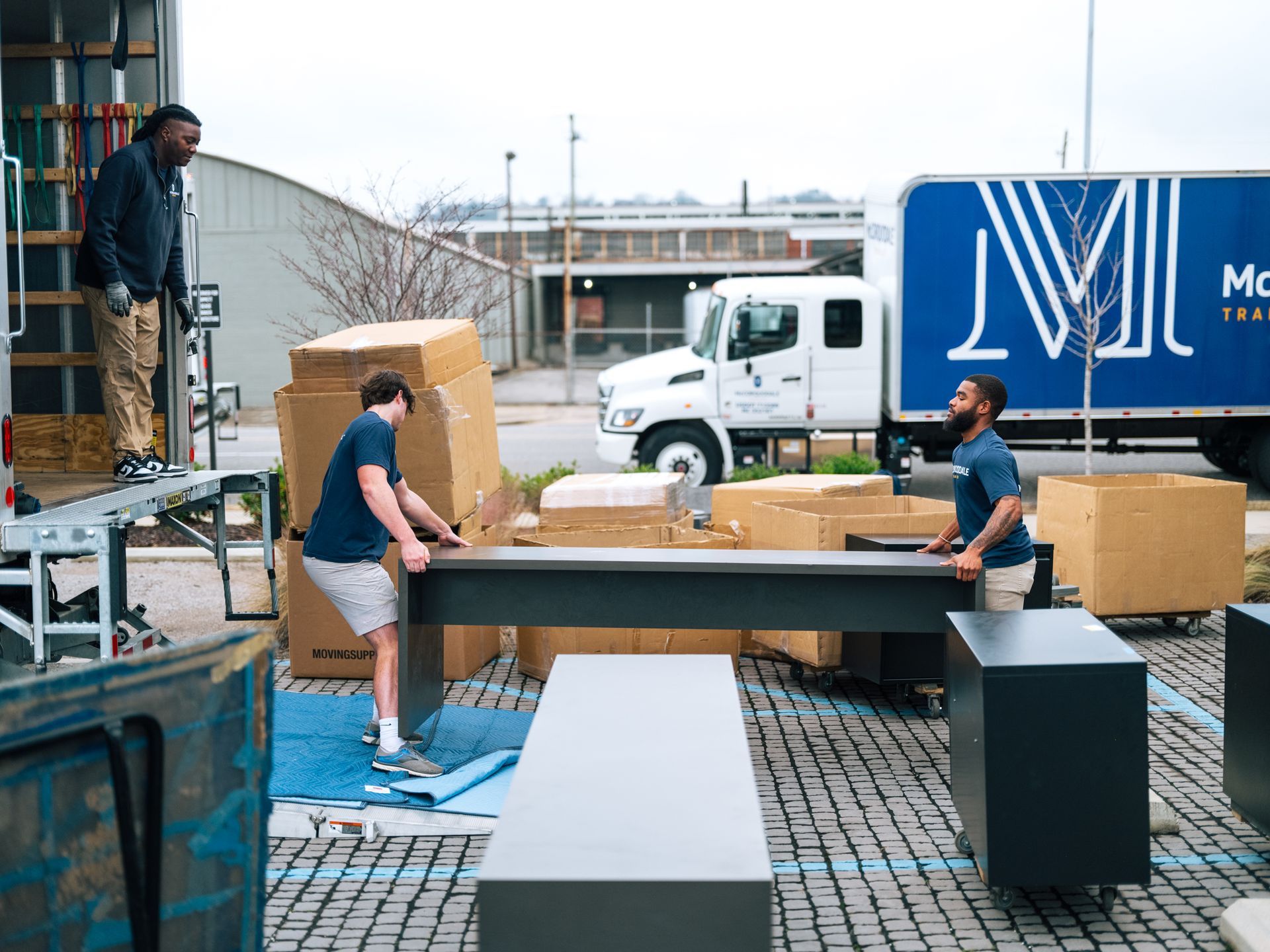 Movers loading furniture into a truck on a loading dock.