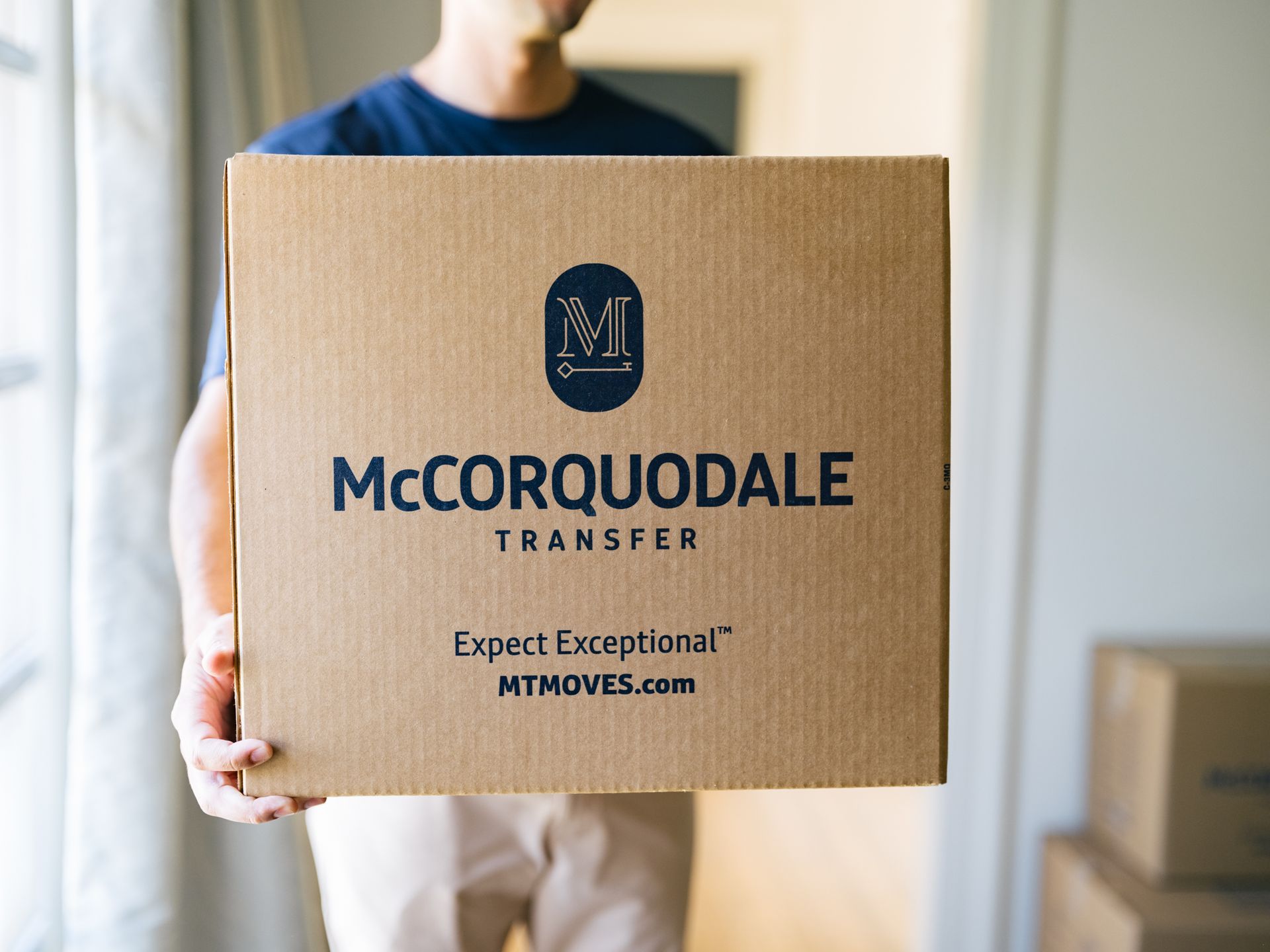 Man holding a cardboard box branded
