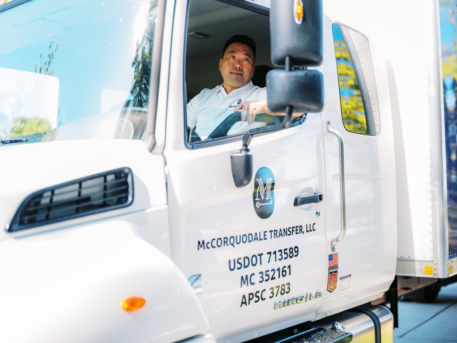 Man in moving truck cab, white truck with