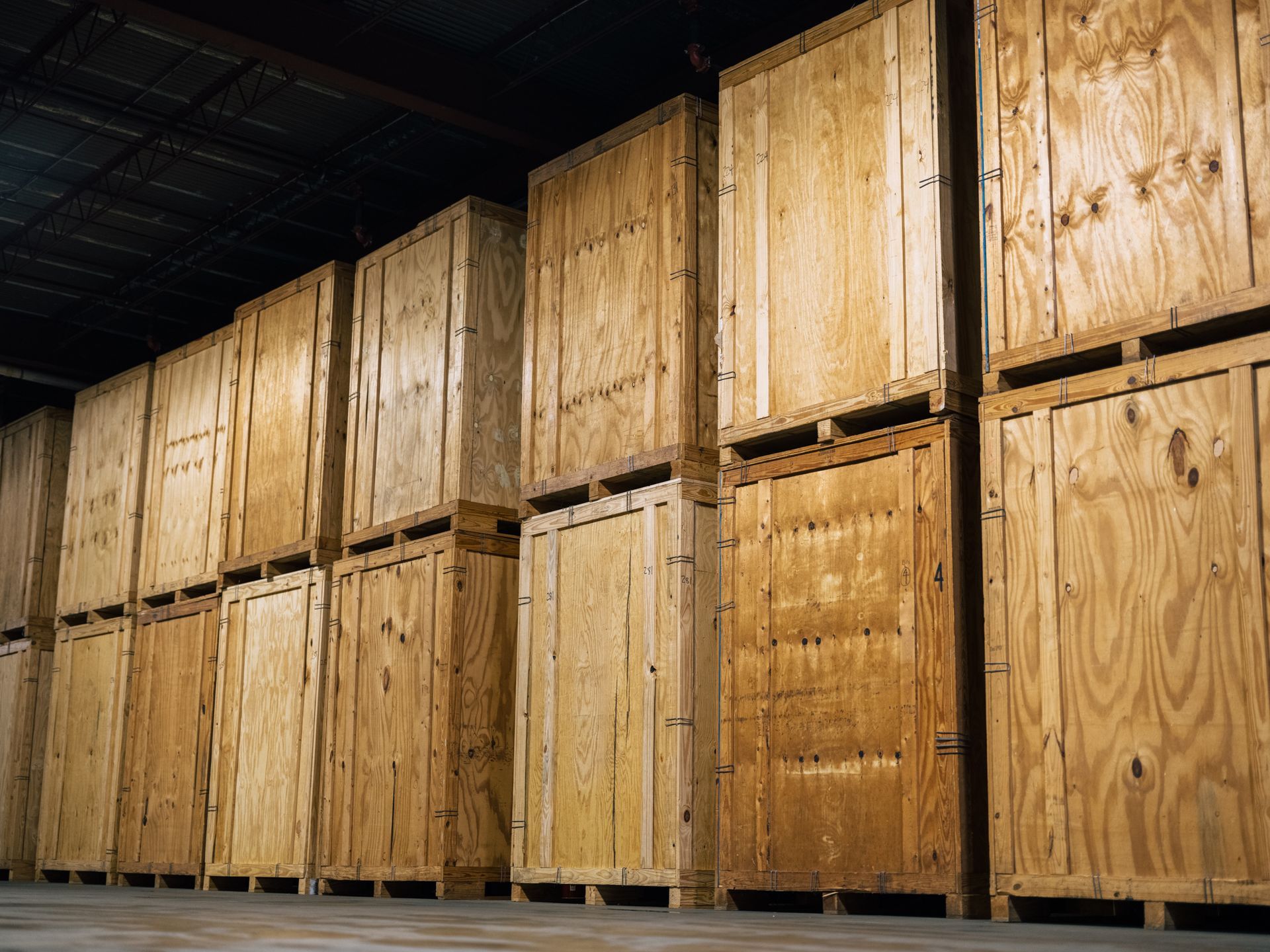 Rows of wooden storage crates stacked in a dimly lit warehouse.