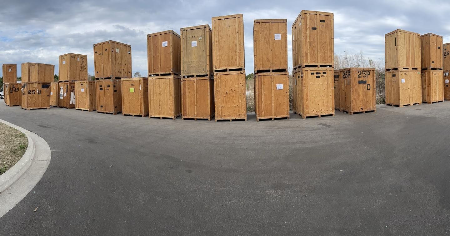A bunch of wooden crates are stacked on top of each other on the side of the road.