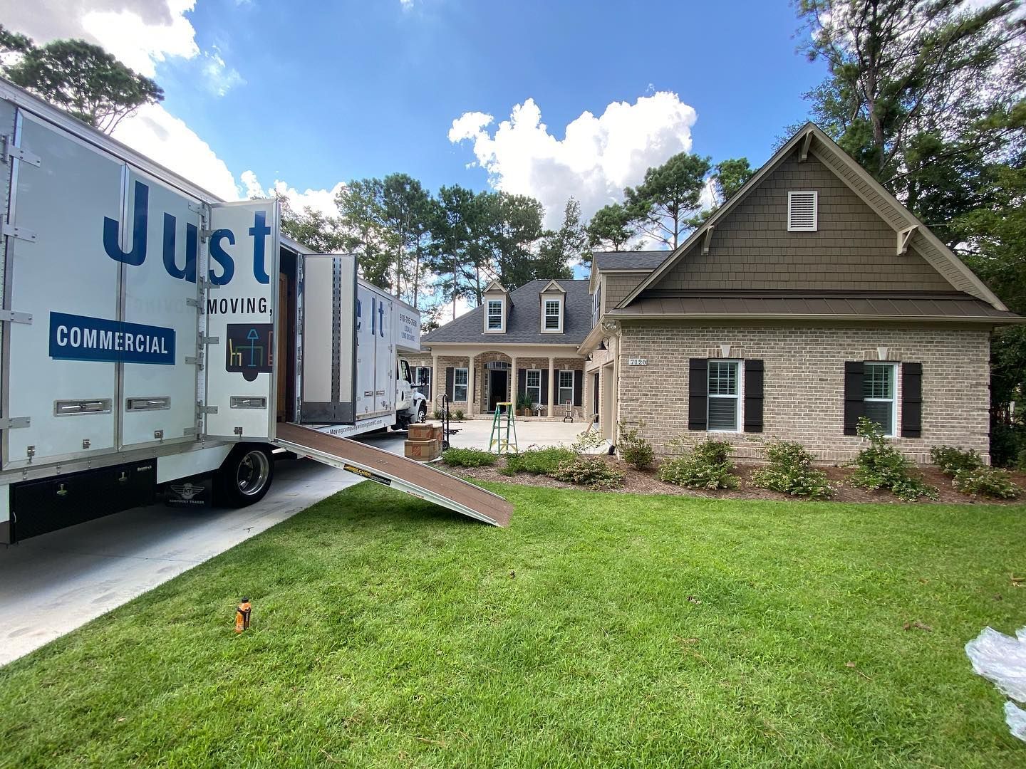 A moving truck is parked in front of a house.