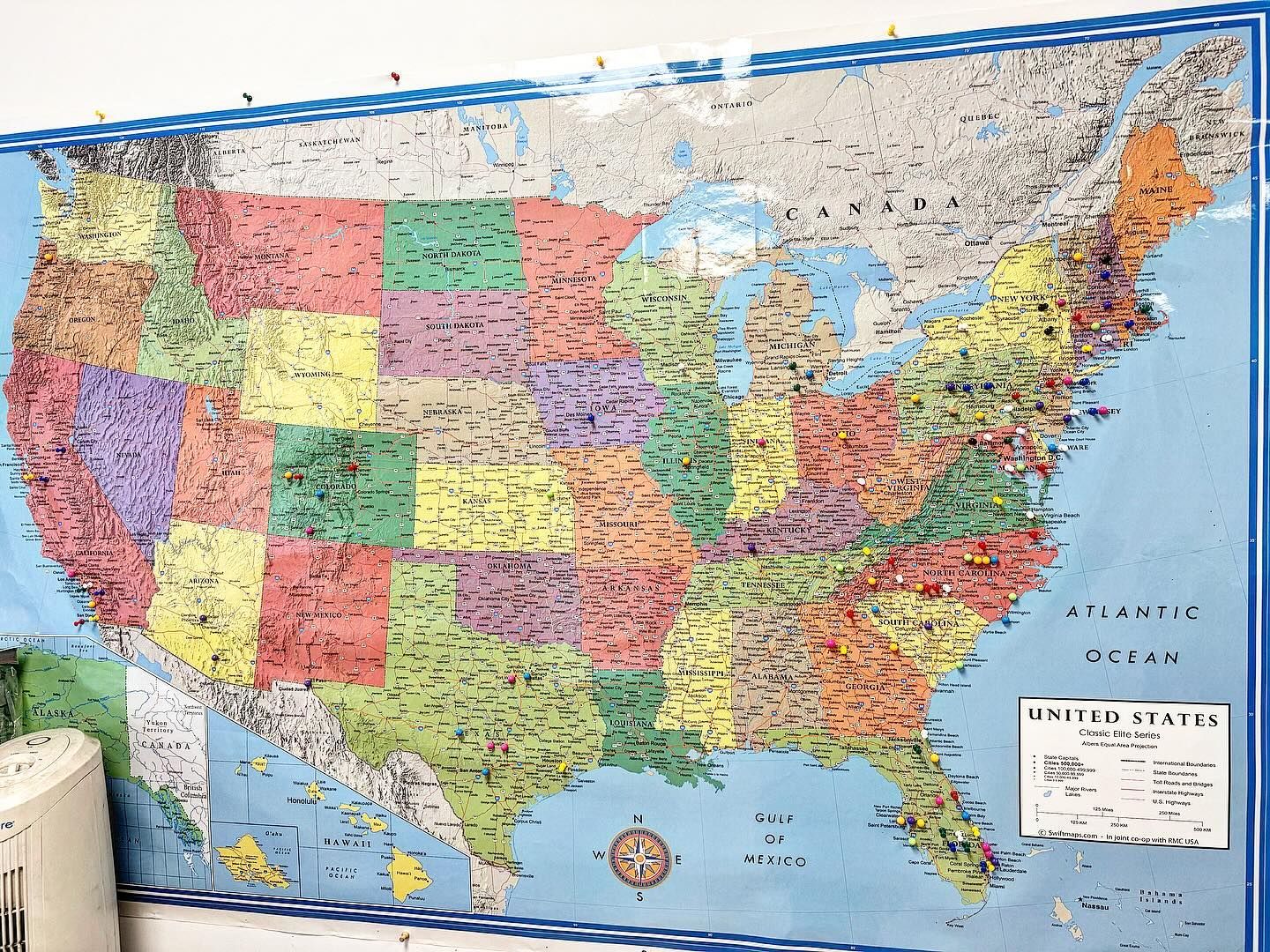 A large map of the united states is hanging on a wall