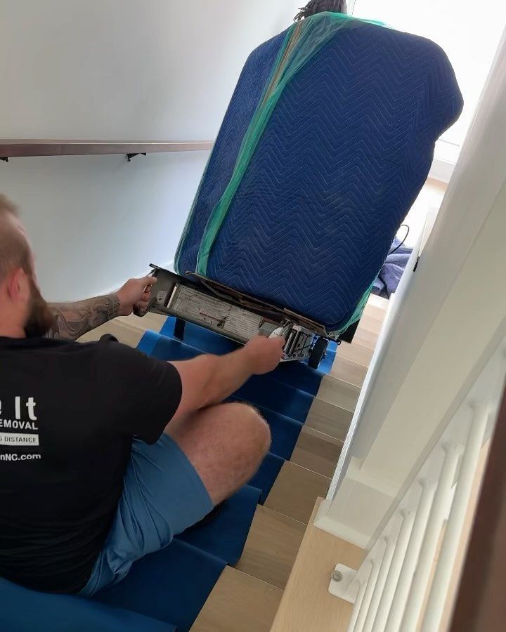 A man is sitting on a set of stairs holding a remote control.