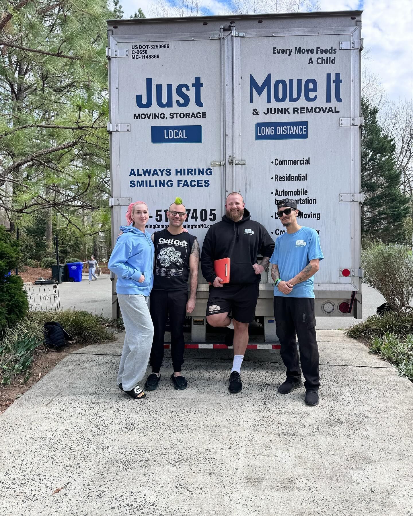 A group of people are standing in front of a moving truck.
