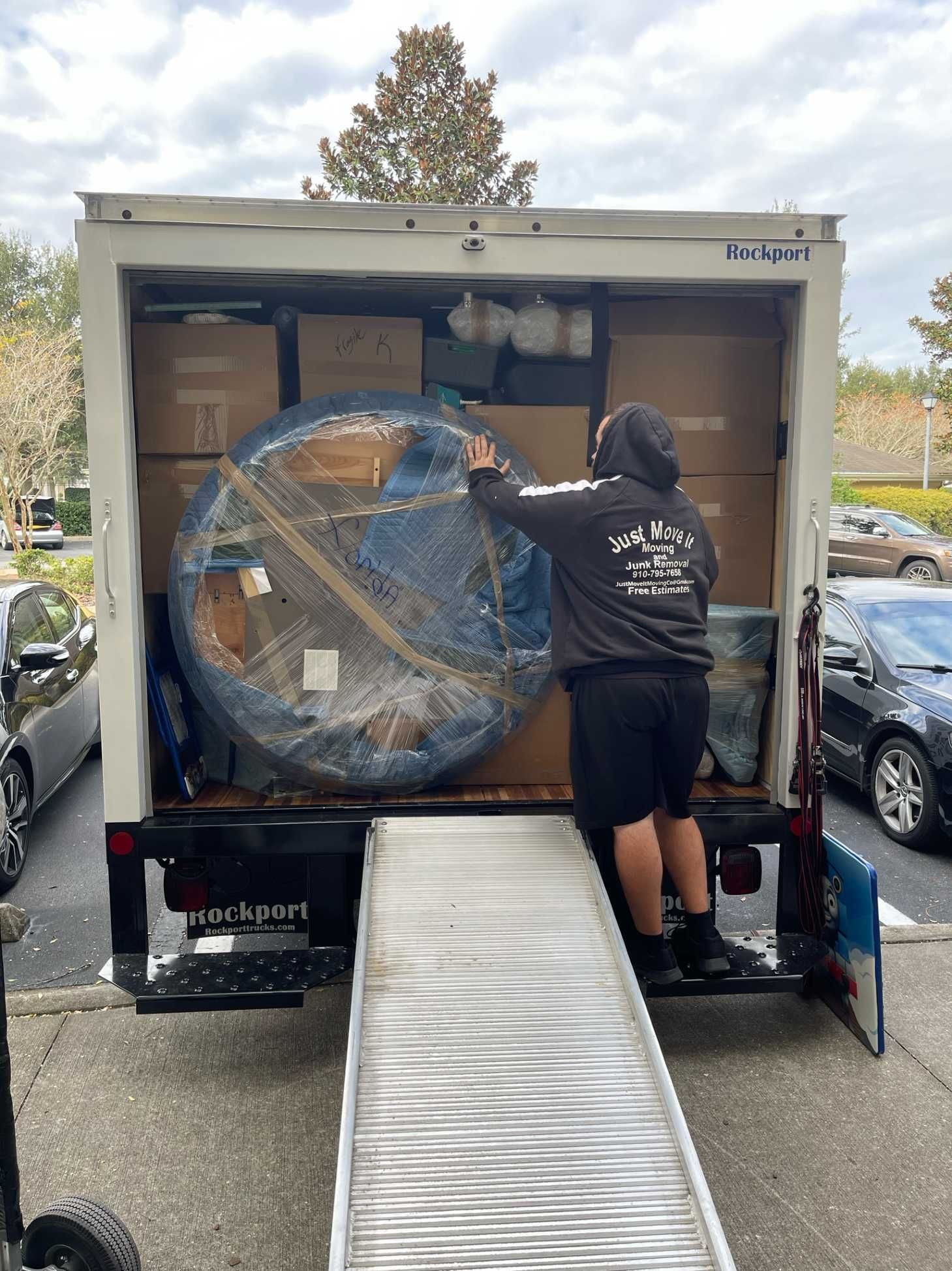 A man is loading a large object into a moving truck.