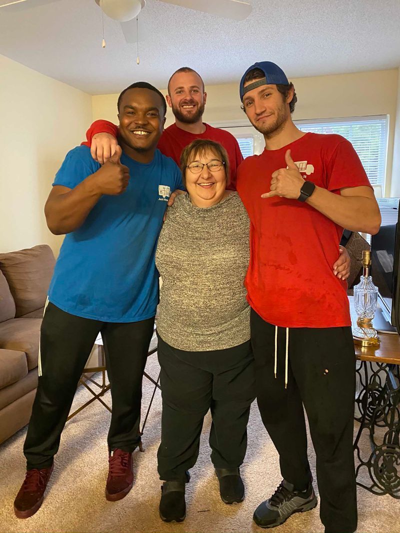 A group of people are posing for a picture in a living room.