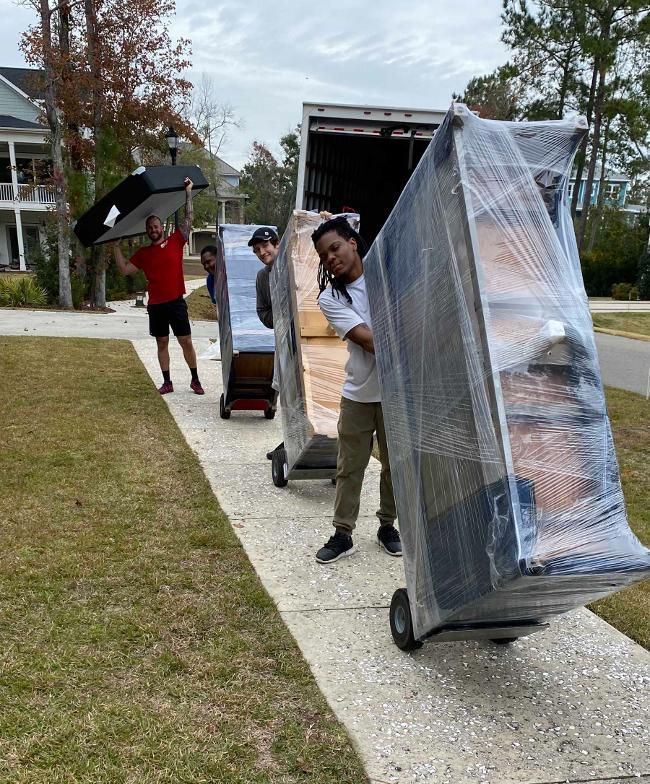 A group of people are carrying furniture out of a truck.