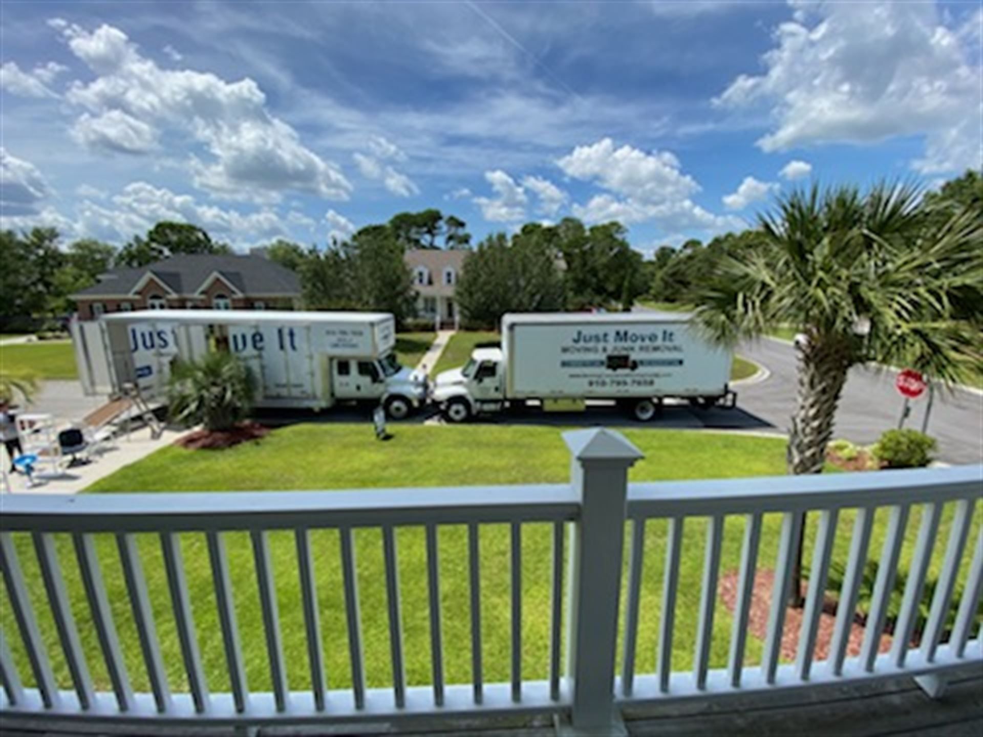 Two moving trucks are parked in front of a house.