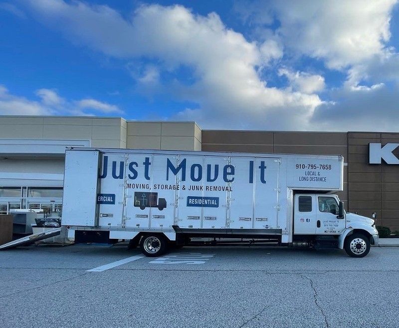 A just move it truck is parked in front of a building