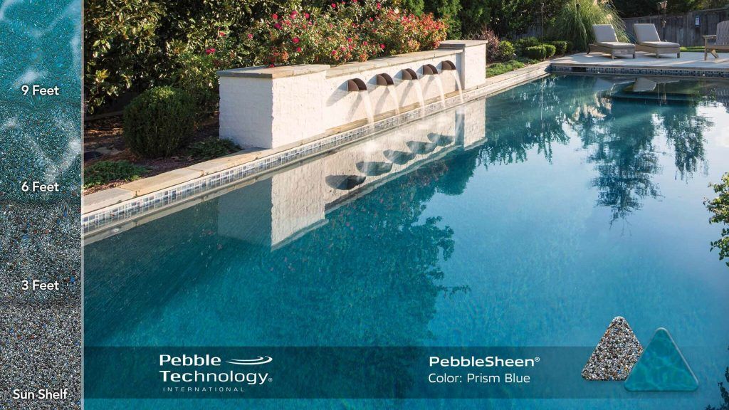 A luxurious turquoise pool with a water fountain and surrounding greenery.
