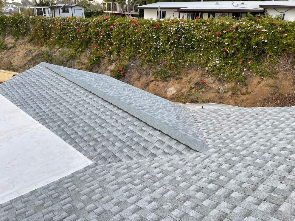 A gray roof is being installed on a house.