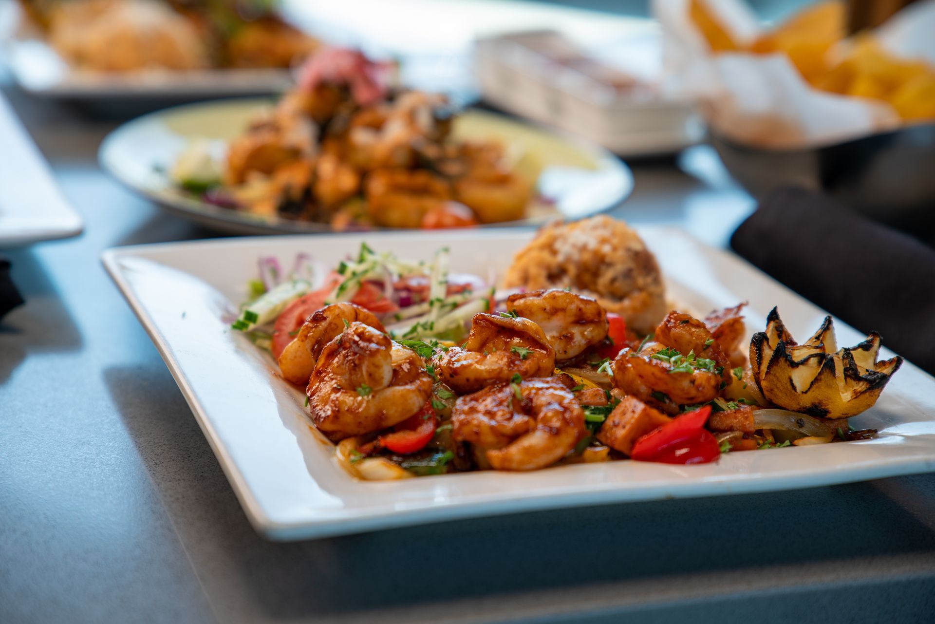 Plate of shrimp with vegetables and a roll.