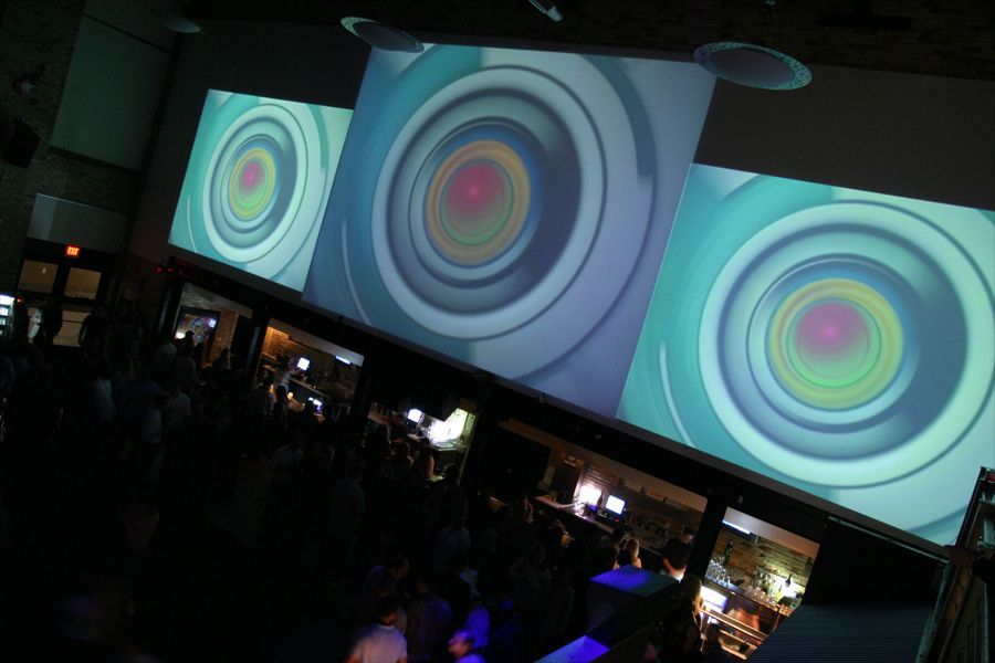 A group of people are standing in front of a large screen with circles on it
