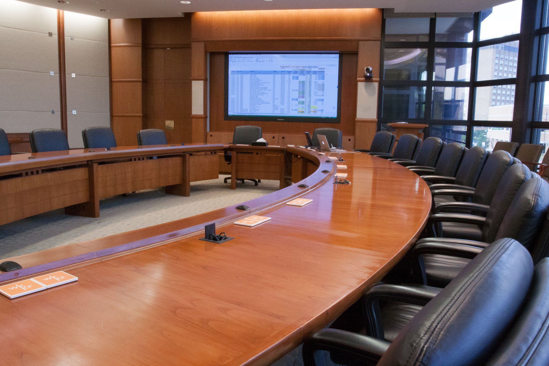 A conference room with a long wooden table and chairs