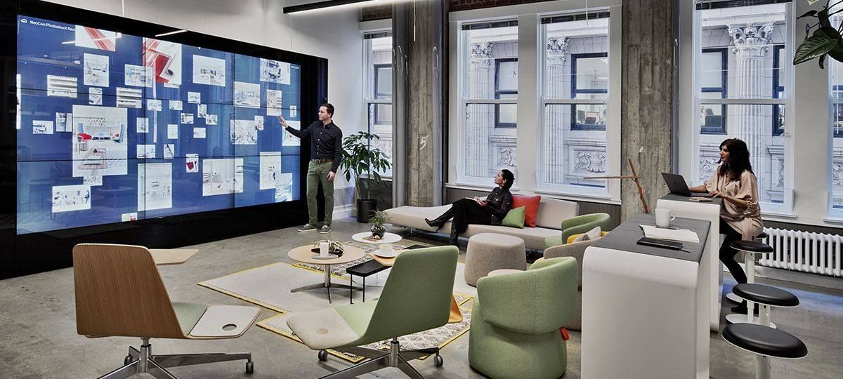 A woman is standing in front of a large screen in a living room.