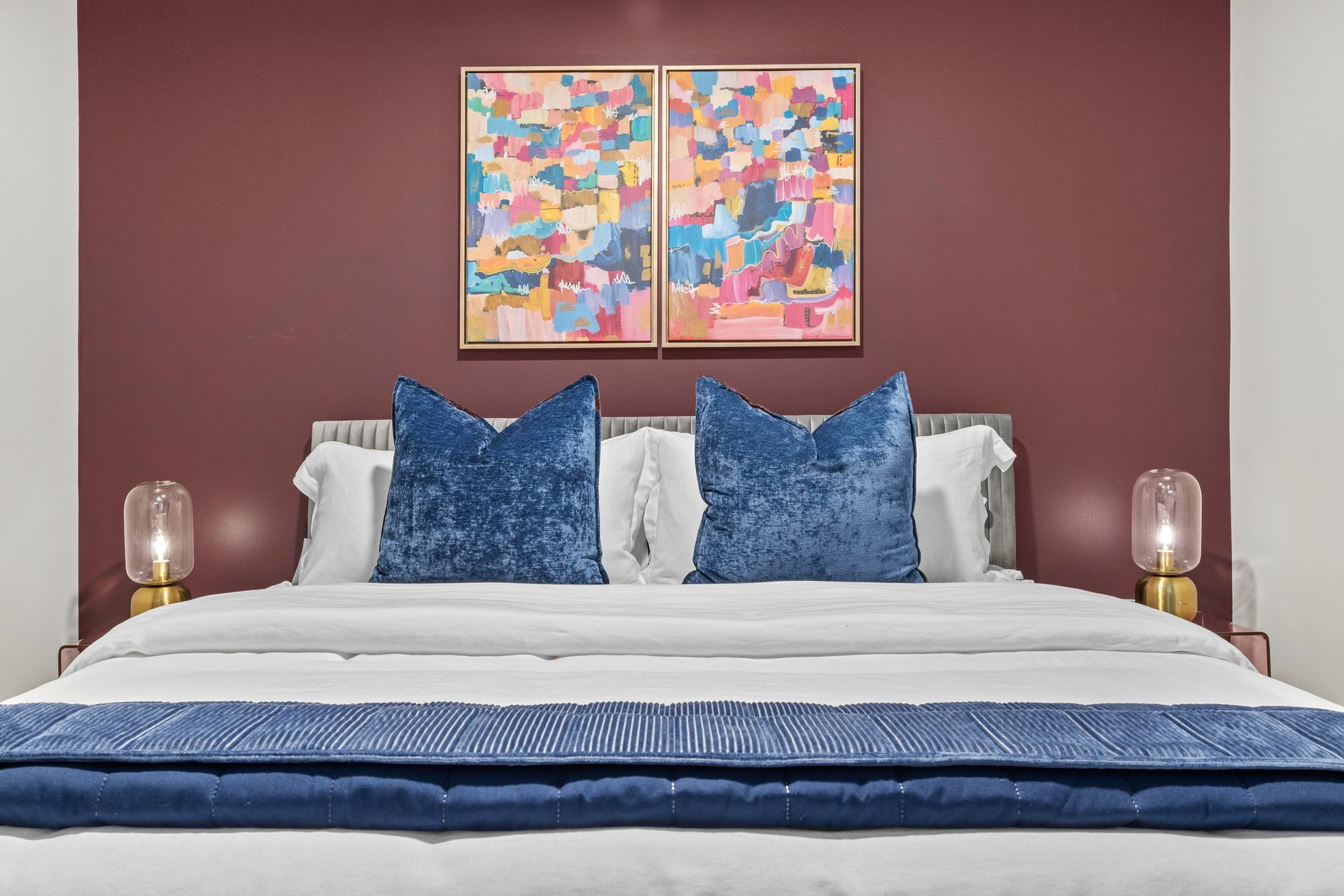 There are two paintings on the wall above the bed.