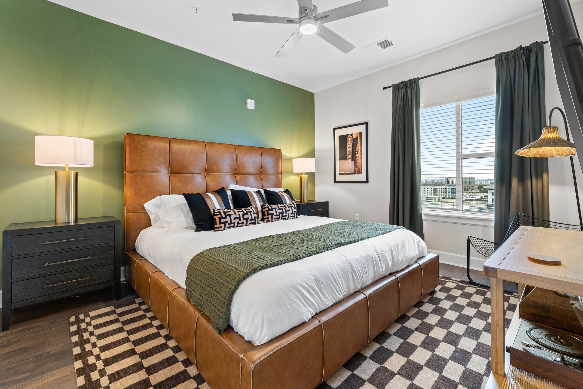 A bedroom with a king size bed and a ceiling fan.