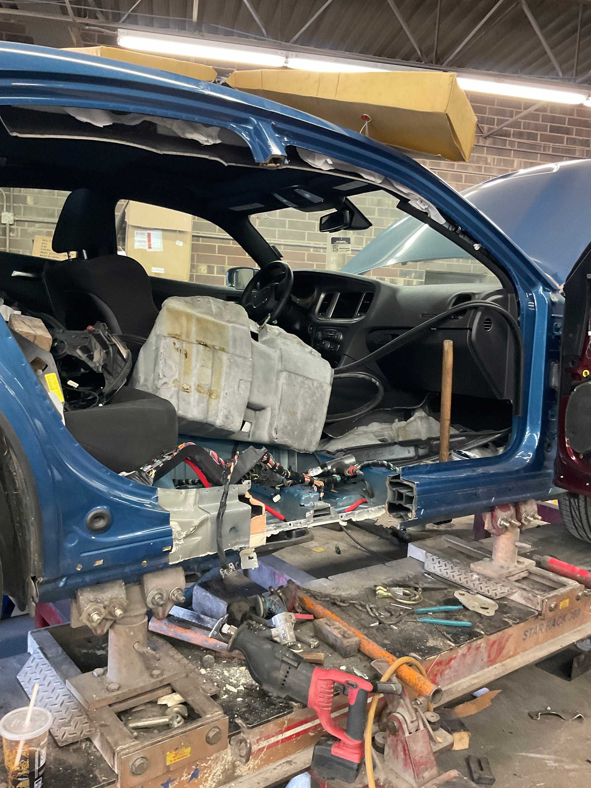 A blue car is sitting on a lift in a garage