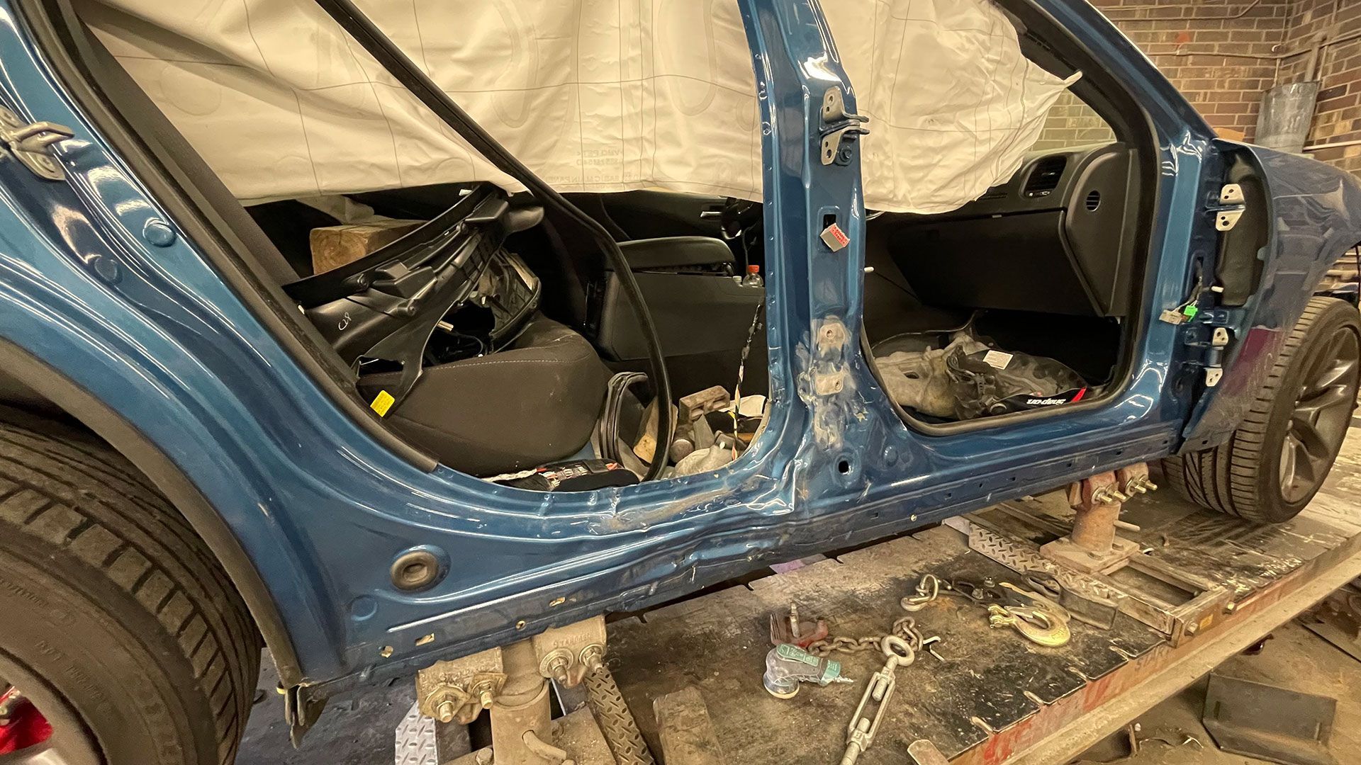 A blue car is being repaired in a garage
