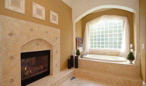 Bathroom with tub and fireplace