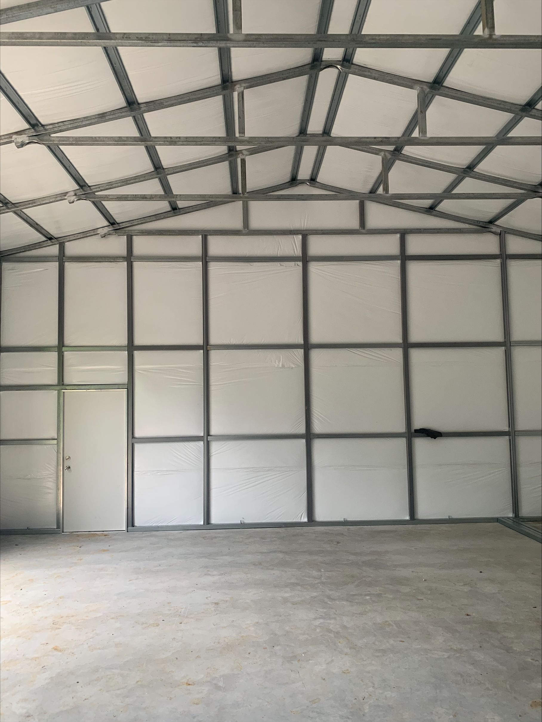 A large empty building with white walls and a door