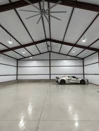 A white sports car is parked in a garage with a ceiling fan.