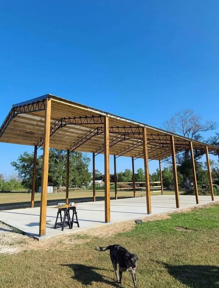 A dog is standing under a wooden structure in a field.