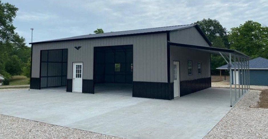A large metal garage with a carport attached to it.