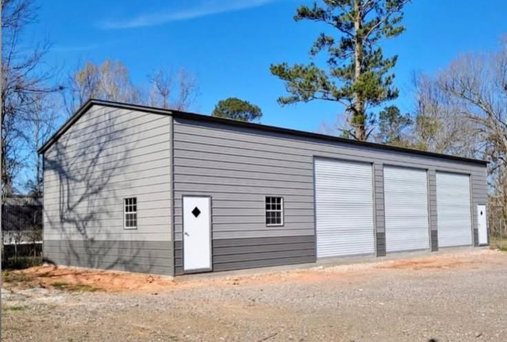 A large garage with three garage doors and a white door