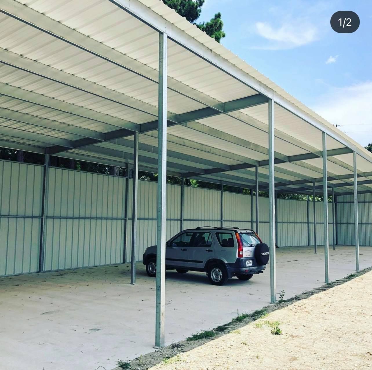 A gray suv is parked under a white roof