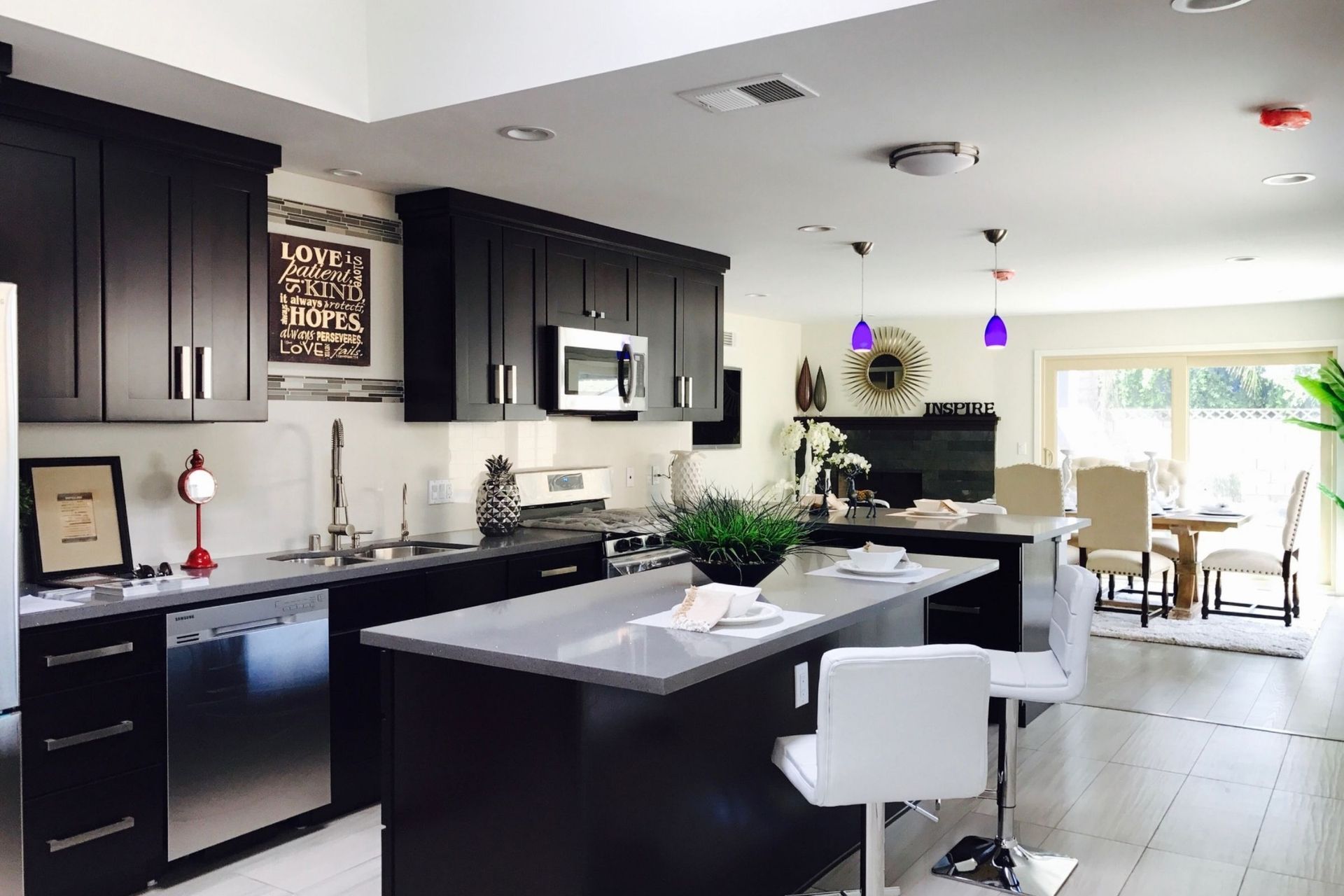 A kitchen with black cabinets and stainless steel appliances
