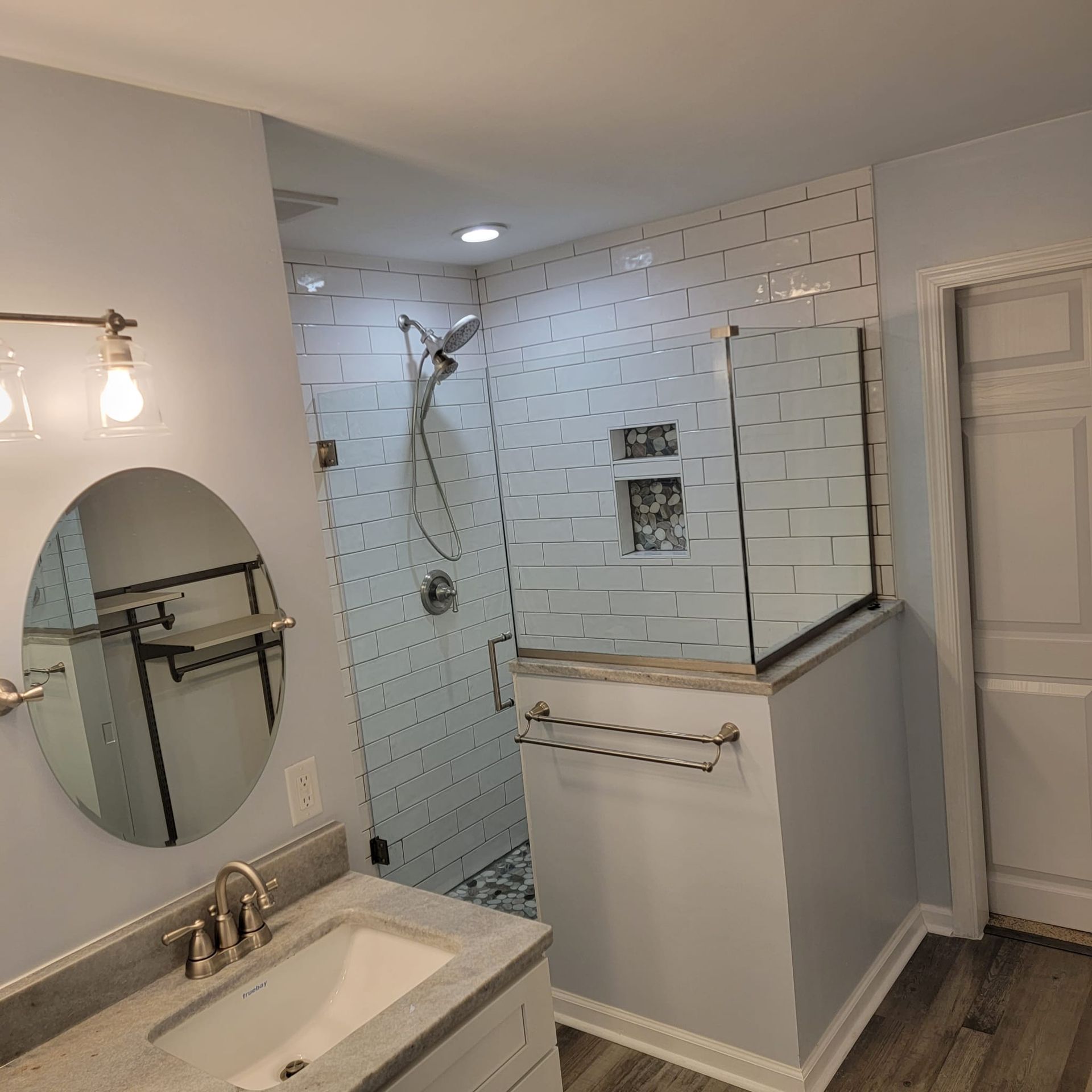 A bathroom with a sink, mirror and shower