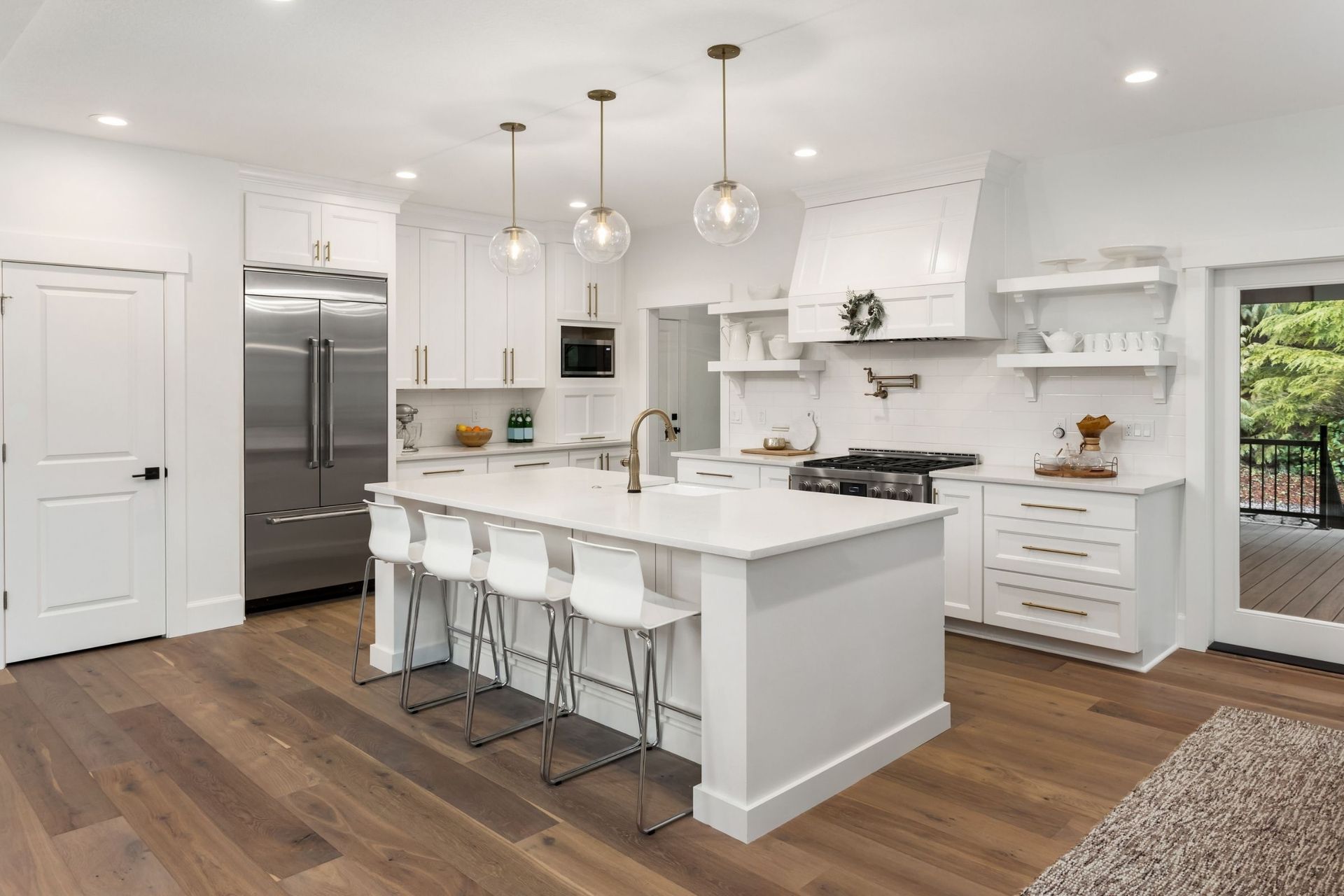 A kitchen with white cabinets and stainless steel appliances and a large island