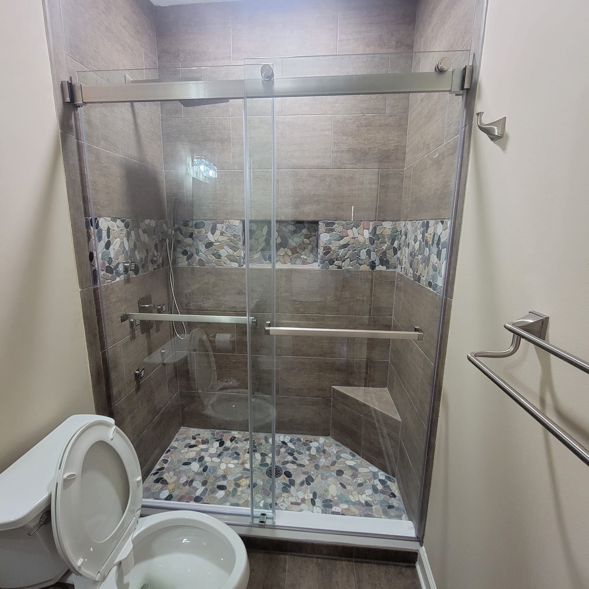 A bathroom with a toilet and a shower with a glass door