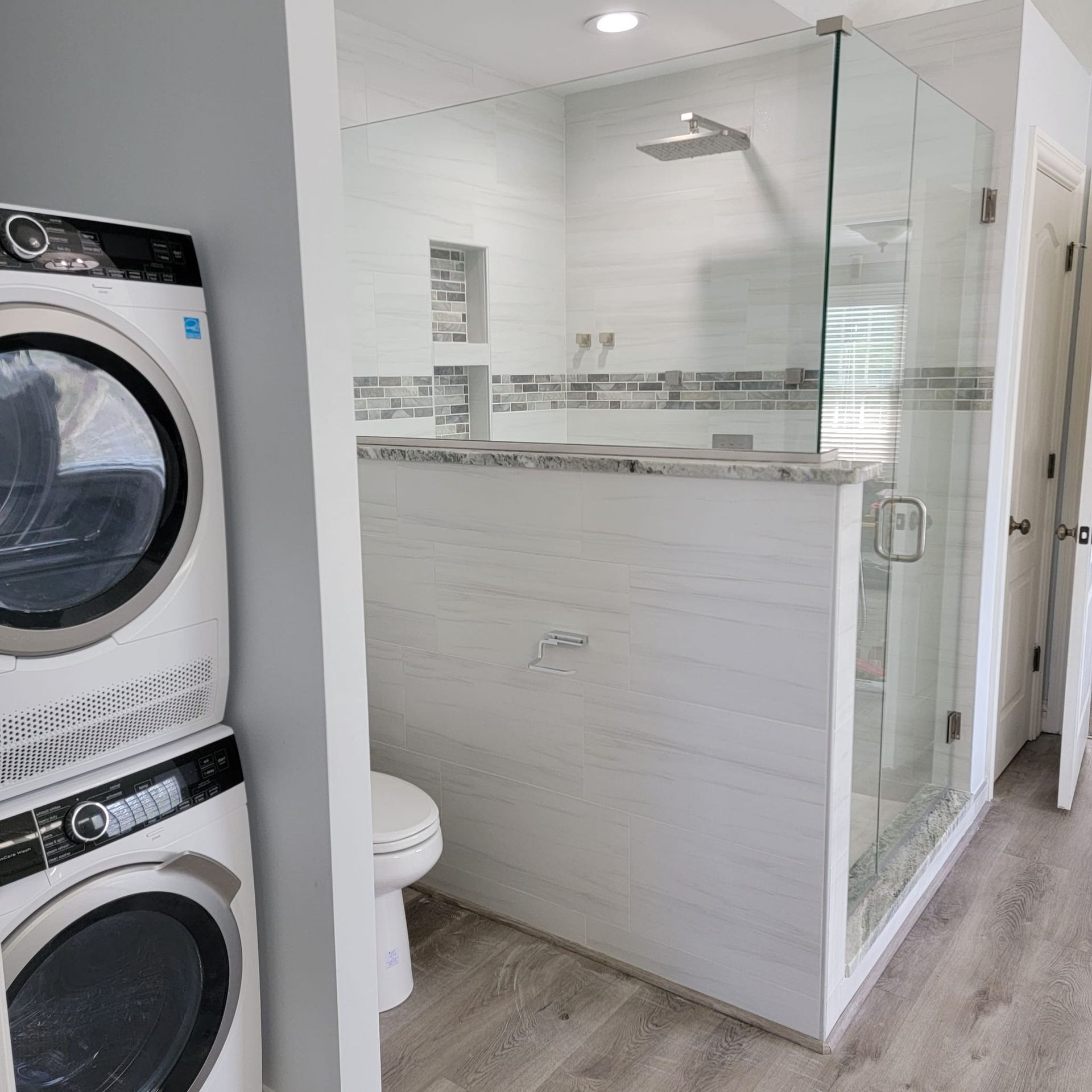 A washer and dryer are stacked on top of each other in a bathroom