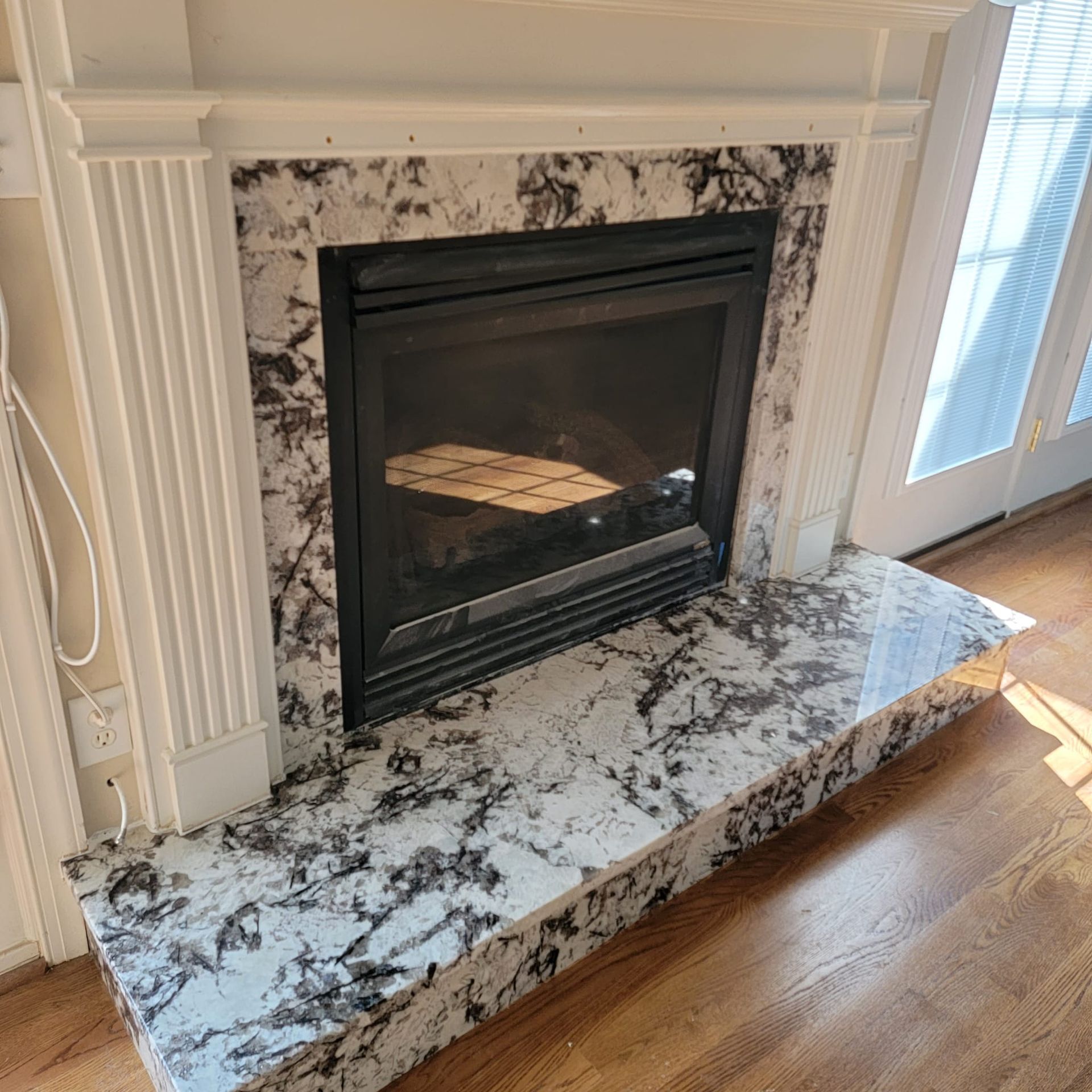 A fireplace with a marble mantle in a living room