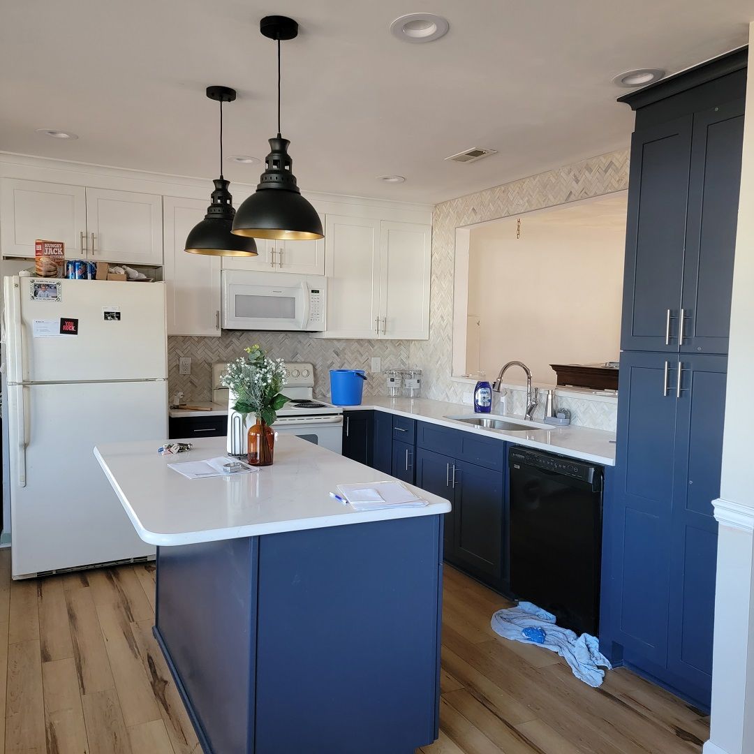 A kitchen with blue cabinets and a white refrigerator