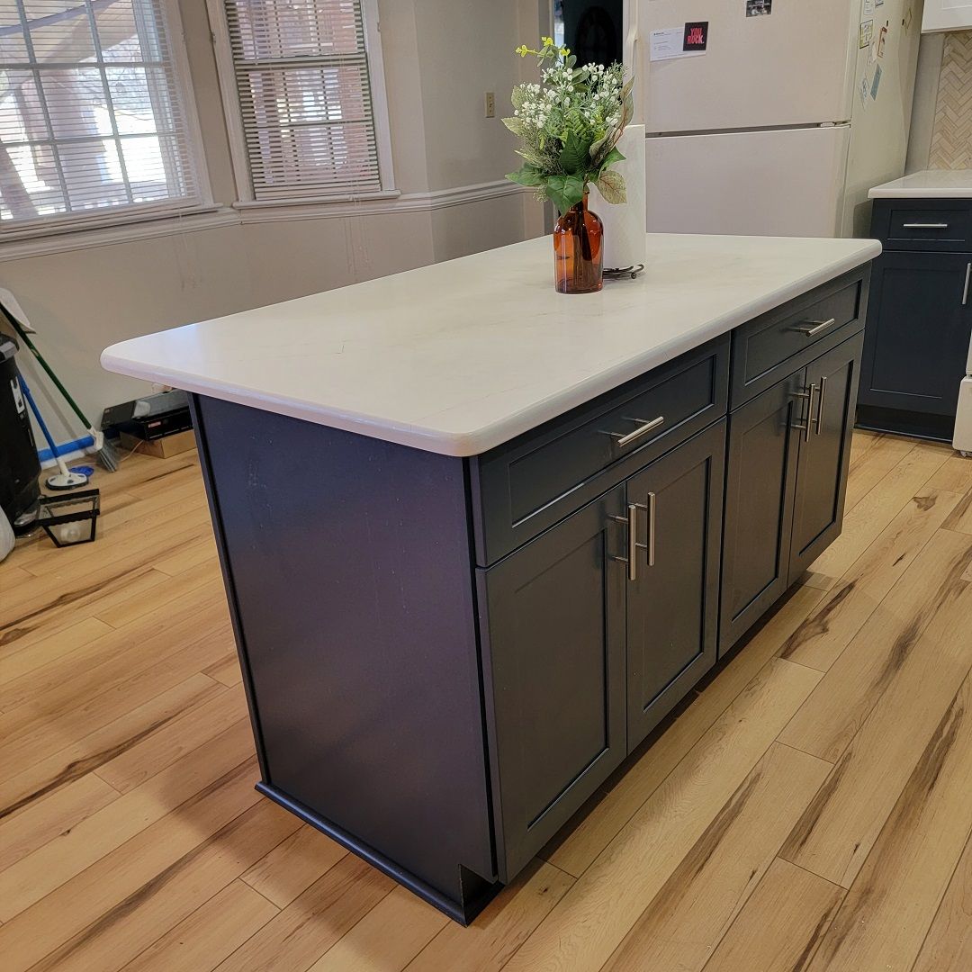 A kitchen island with a vase of flowers on top of it