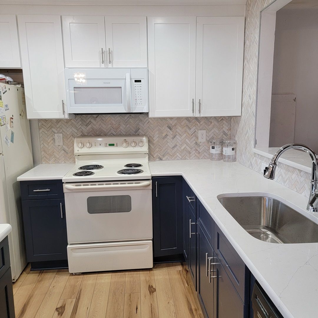 A kitchen with a stove, sink, microwave and refrigerator