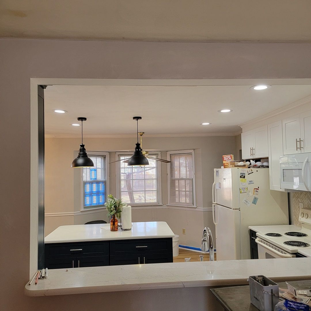 A kitchen with a stove, refrigerator, microwave, and sink