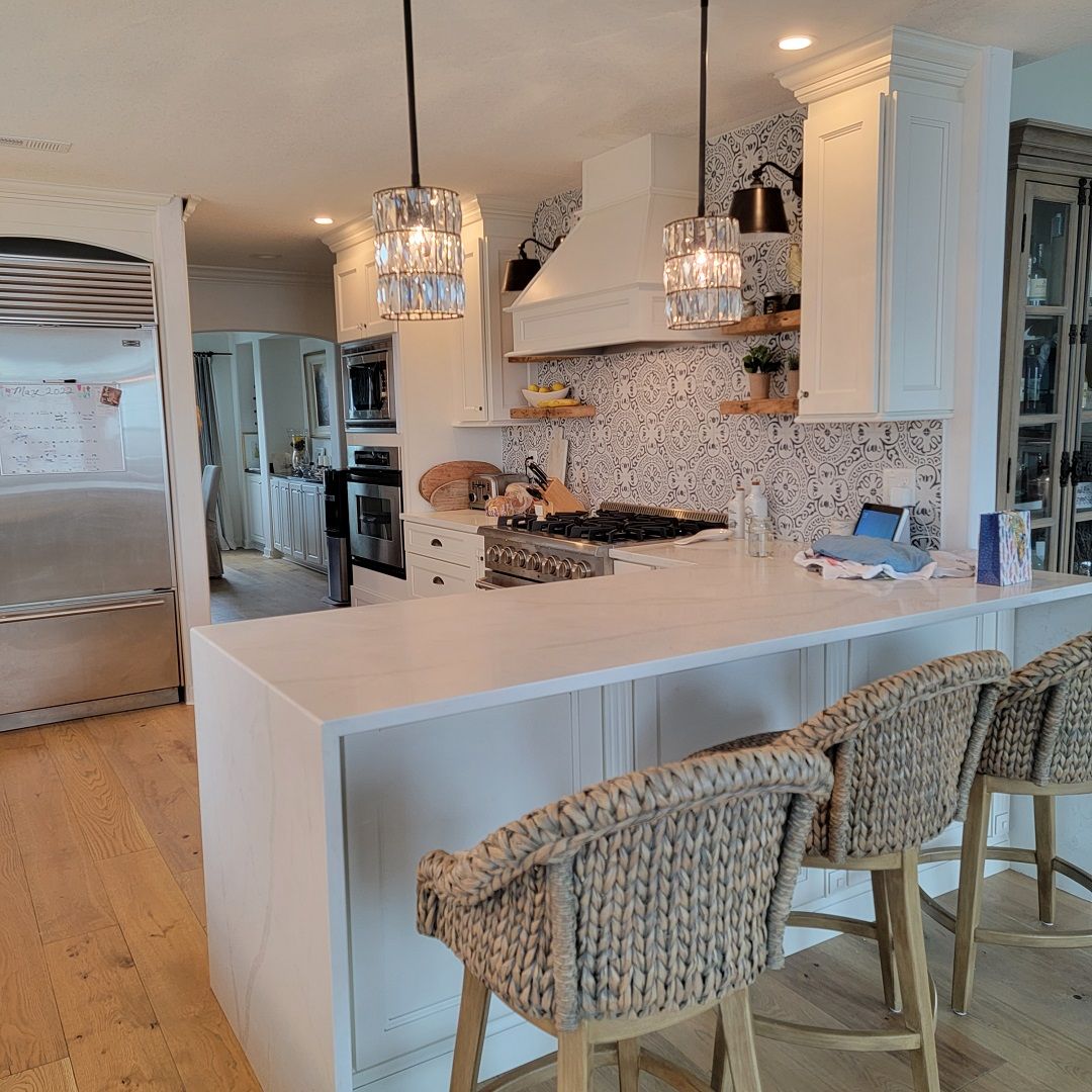 A kitchen with a large island and wicker chairs