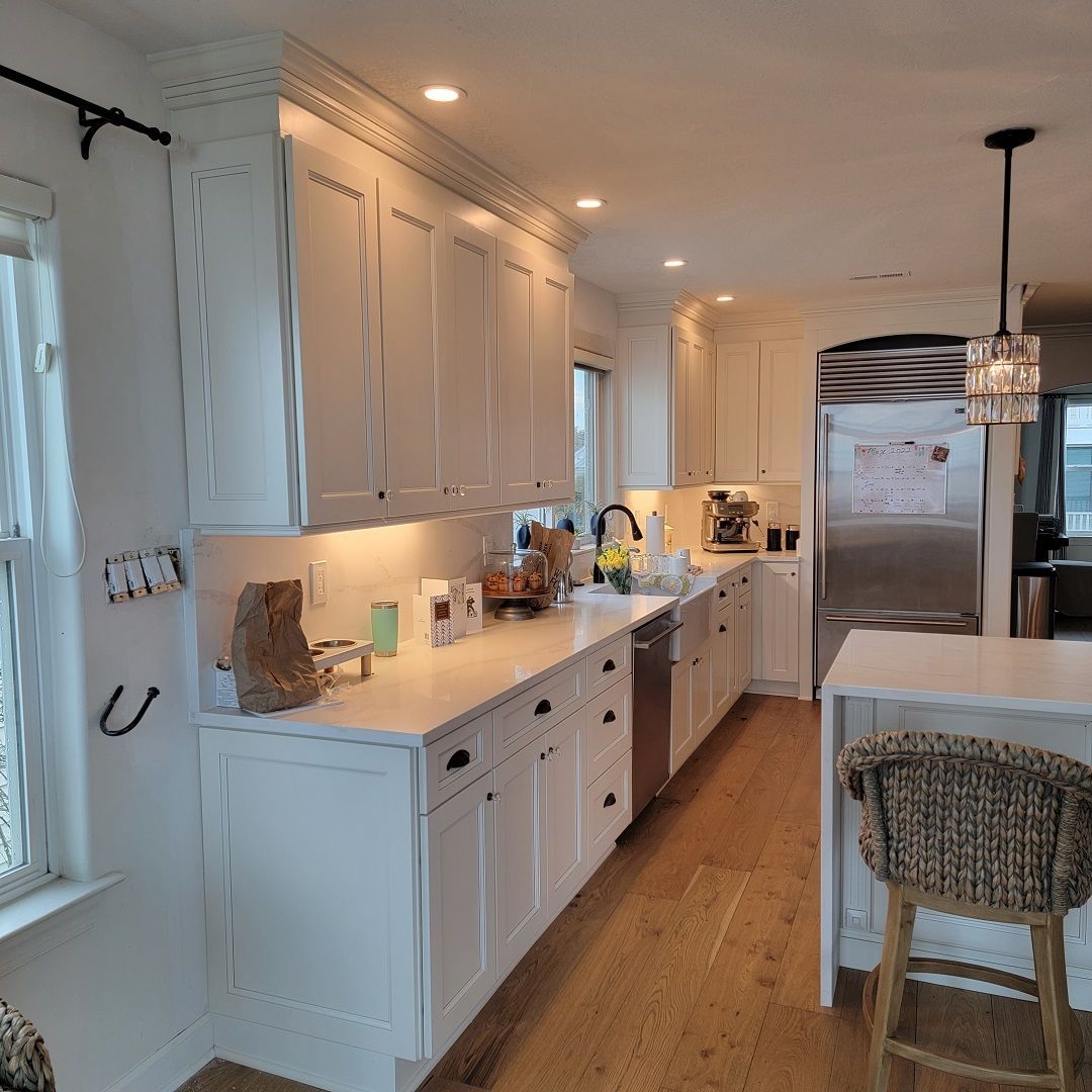 A kitchen with white cabinets and stainless steel appliances