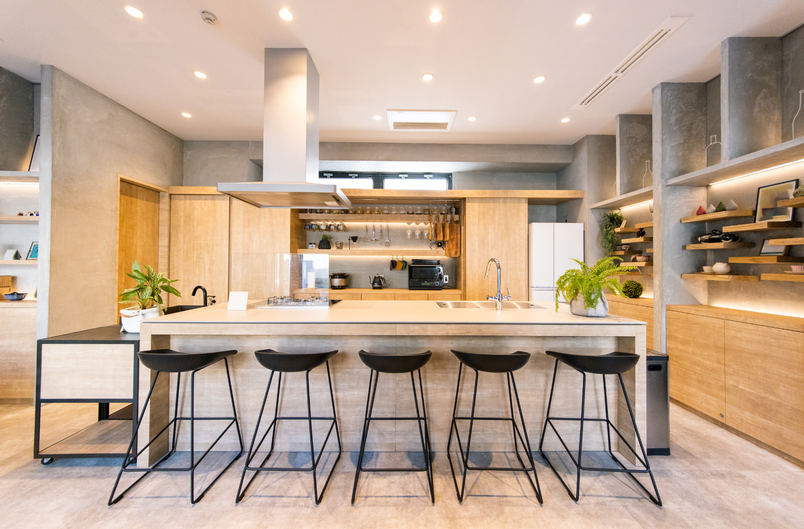 A kitchen with a long island and stools in it