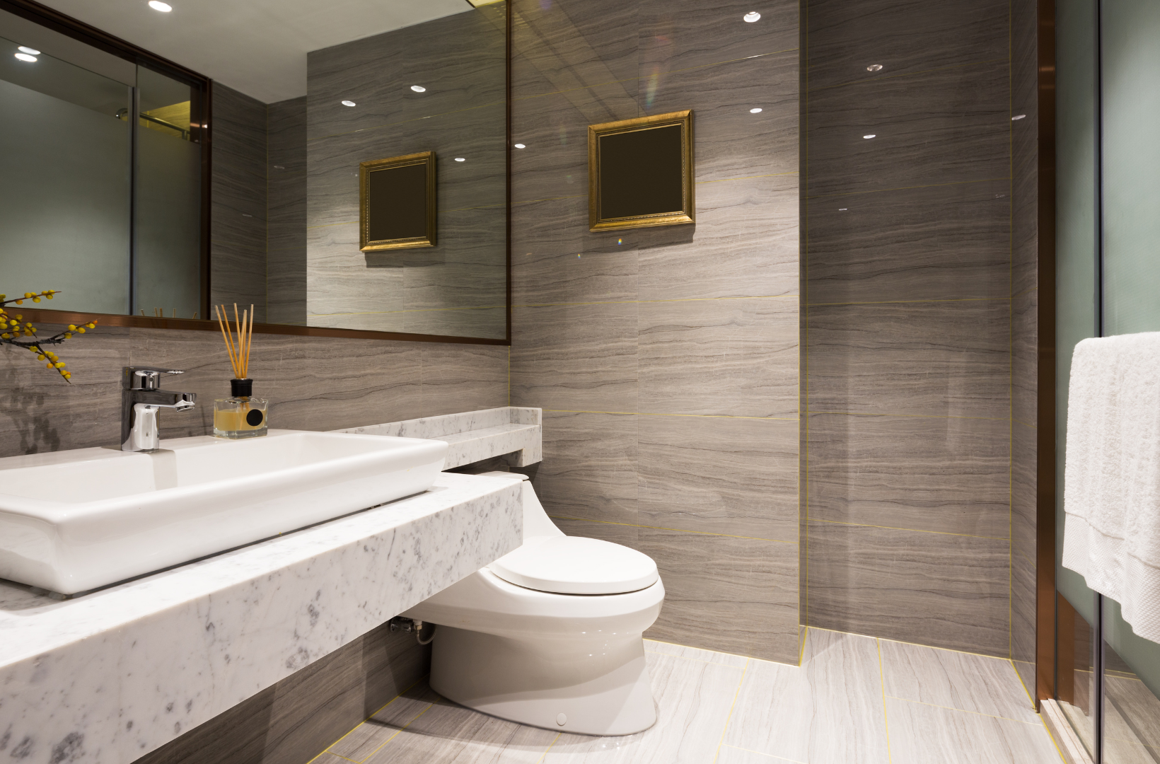 A bathroom with a toilet, sink, mirror and walk in shower