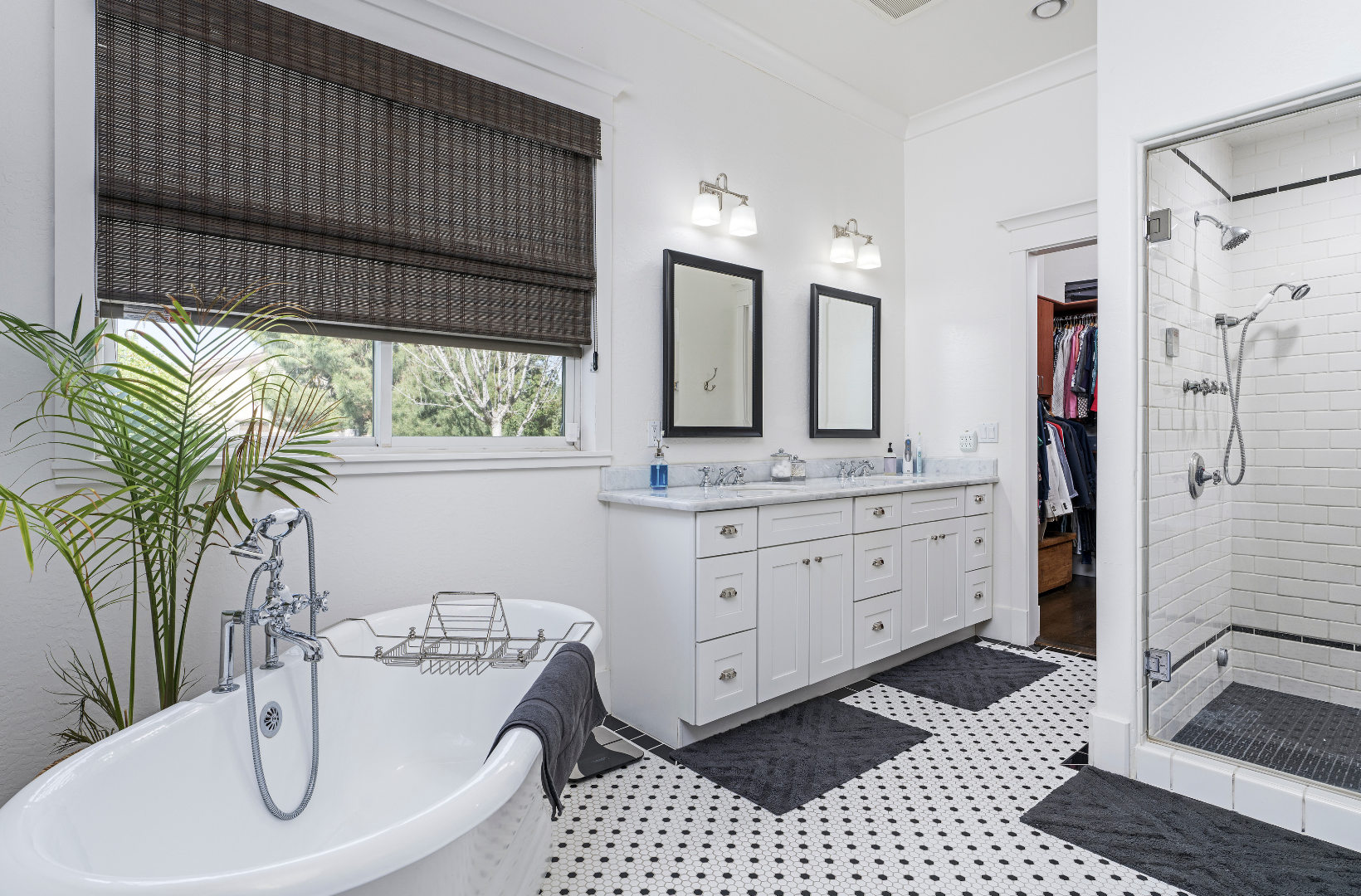 A bathroom with a tub, sink, mirrors and a walk in shower