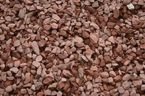 A close-up view of crushed red and tan decorative gravel stones.