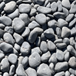 A close-up view of numerous smooth, rounded gray river stones filling the frame.