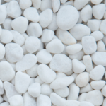A close-up view of numerous smooth, white, rounded decorative garden stones packed together.